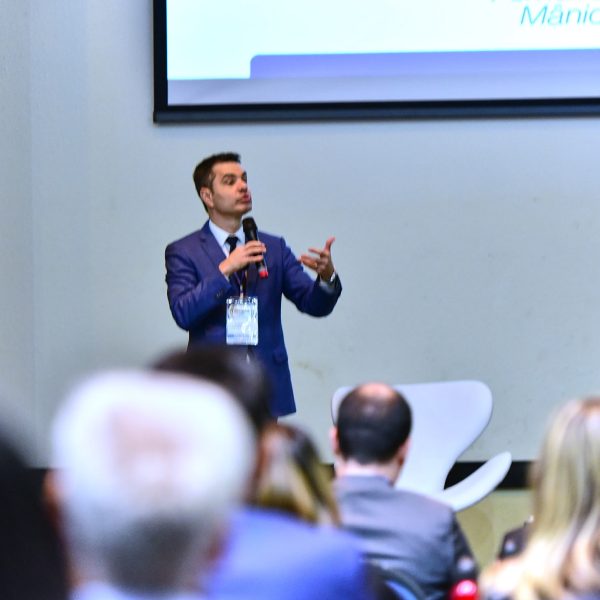 Palestrante fala à plateia em sala de evento