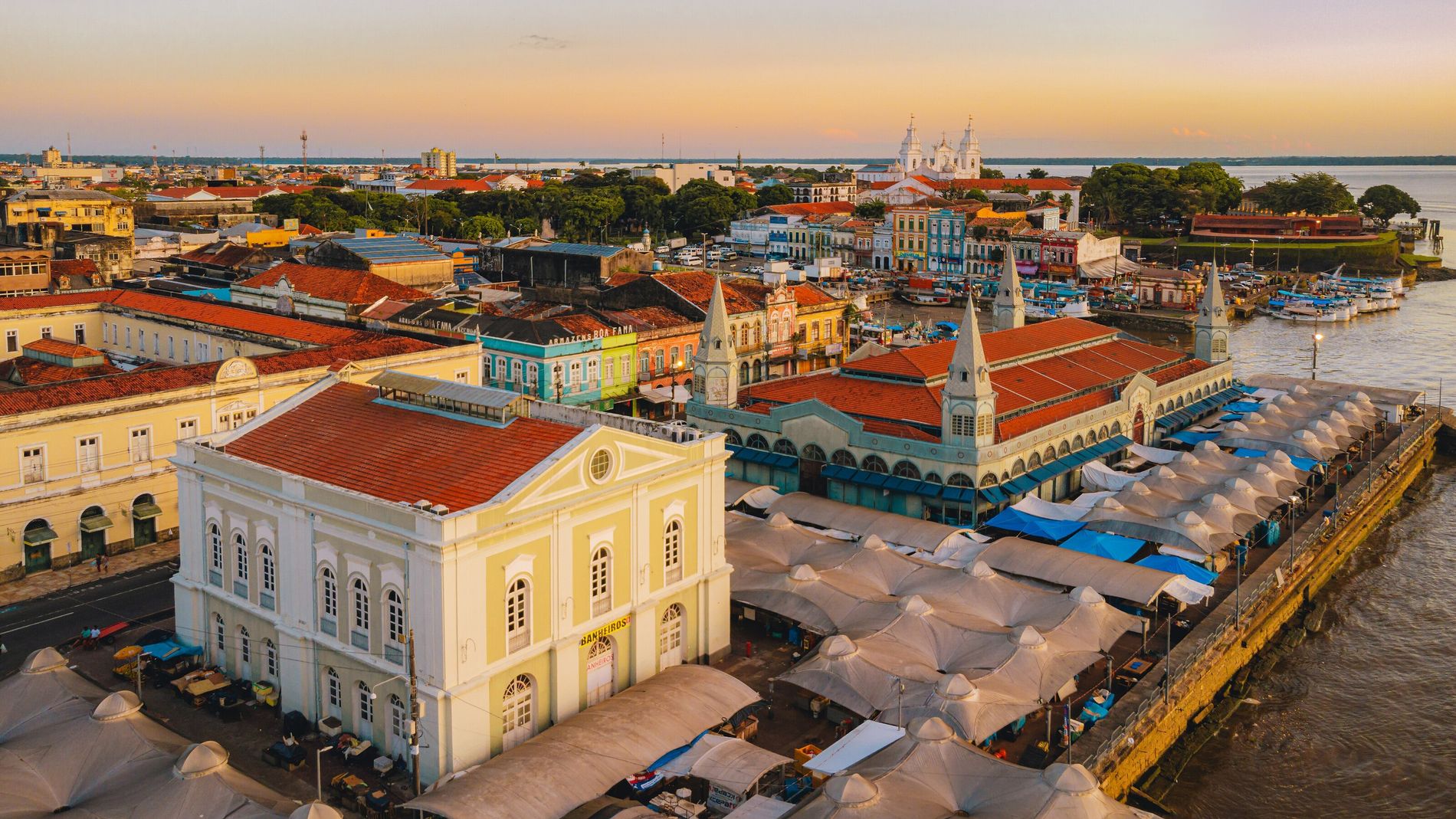 Vista aérea do centro histórico de Belém do Pará, com o Mercado Ver-o-Peso, a Basílica de Nazaré ao fundo e o rio Guamá
