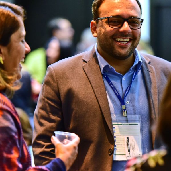 Participantes conversam sorrindo durante o intervalo de uma capacitação